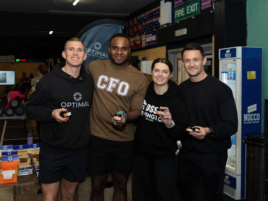 Athletes posing together indoors with Optimal CBD Muscle Balm in a gym and community training setting. 